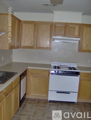 A kitchen with wooden cabinets and a white stove.