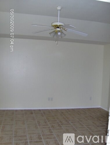A room with a ceiling fan and tile flooring.