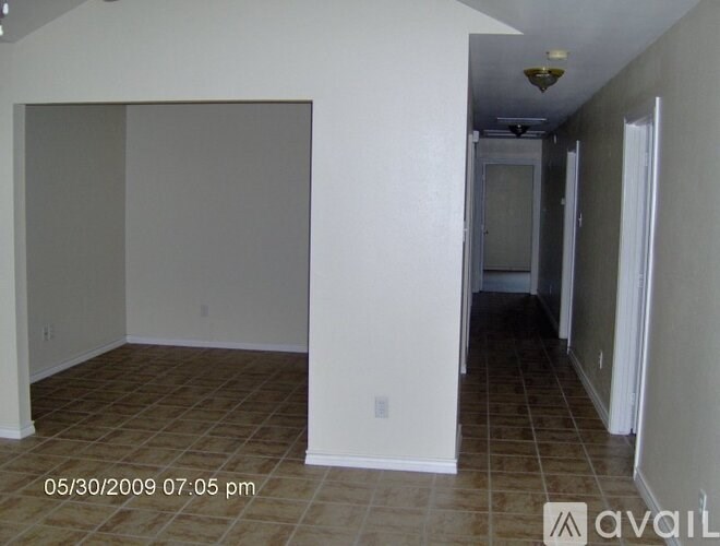 A room with tiled flooring and a doorway leading to another room.