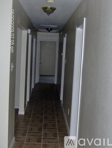A long hallway with tiled floors and white walls.