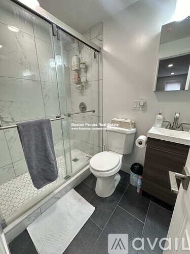 A bathroom with a toilet, sink, and shower.