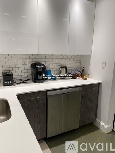 A kitchen with a white counter top and a coffee maker on it.