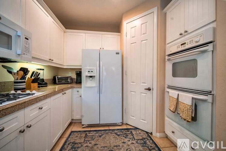 A kitchen with white appliances and cabinets.