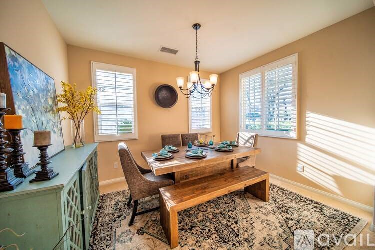 A dining room with a wooden table and chairs.