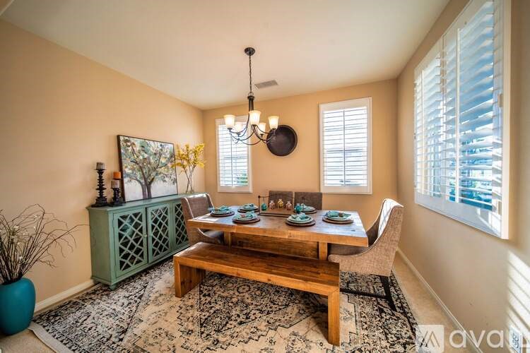 A dining room with a wooden table and chairs.