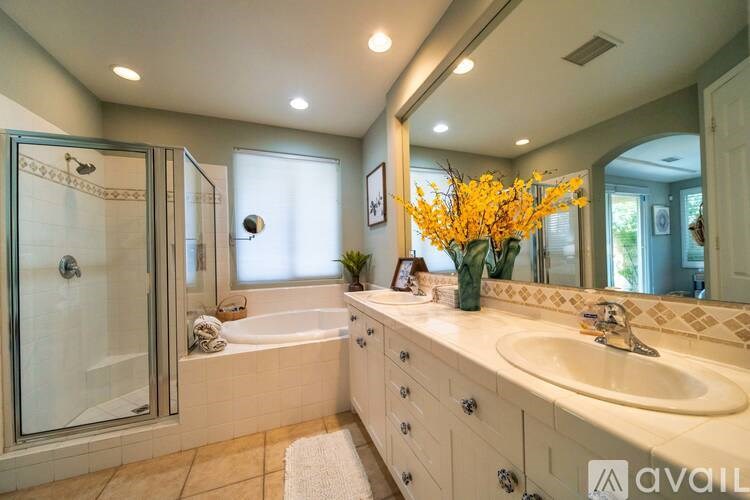 A bathroom with a tub, sink, and mirror.