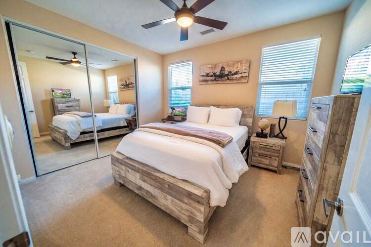 A bedroom with a bed, dresser, and mirror.