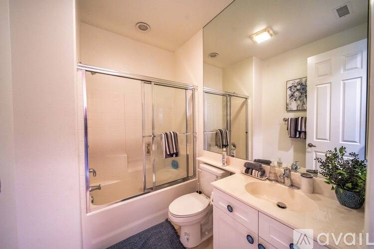 A bathroom with a toilet, sink, and mirror.