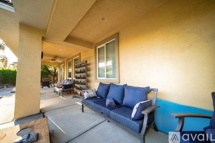 A blue couch with pillows is on a patio.