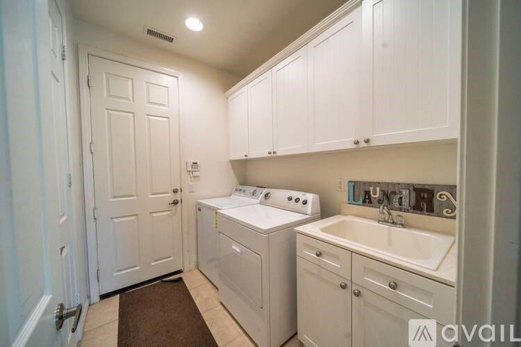 A small, clean, white kitchen with a washer and dryer built in.
