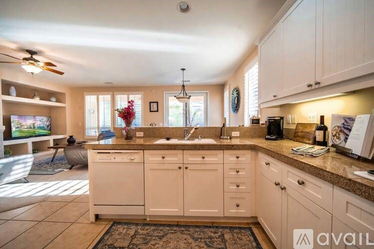 A kitchen with white cabinets and a tiled floor.