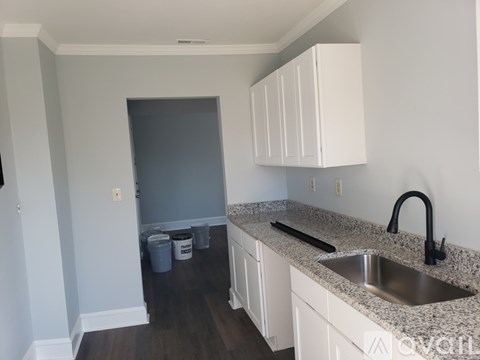 A kitchen with white cabinets and a granite countertop.