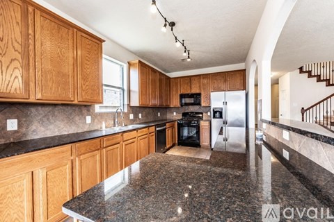 A kitchen with wooden cabinets and granite countertops.
