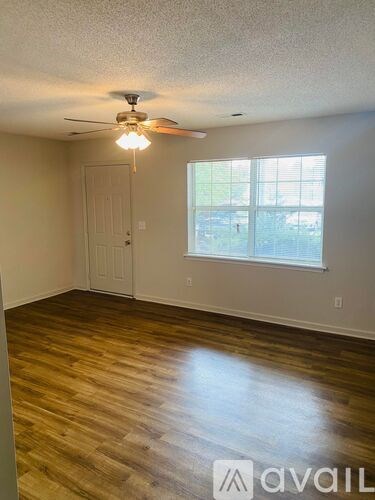 A room with a carpeted floor and a ceiling fan.