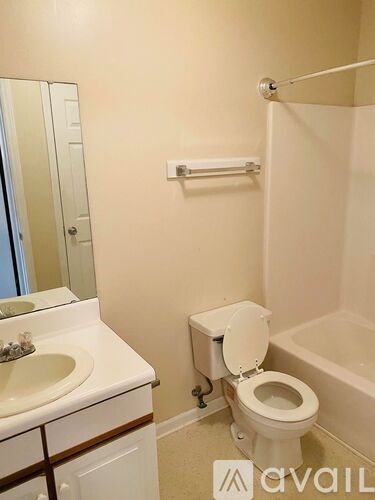 A bathroom with a toilet, sink, and bathtub.