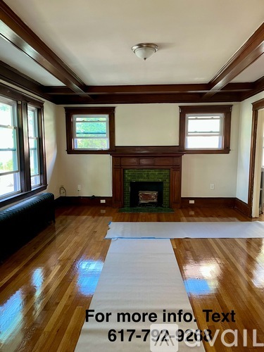 A living room with a fireplace and a large rug.