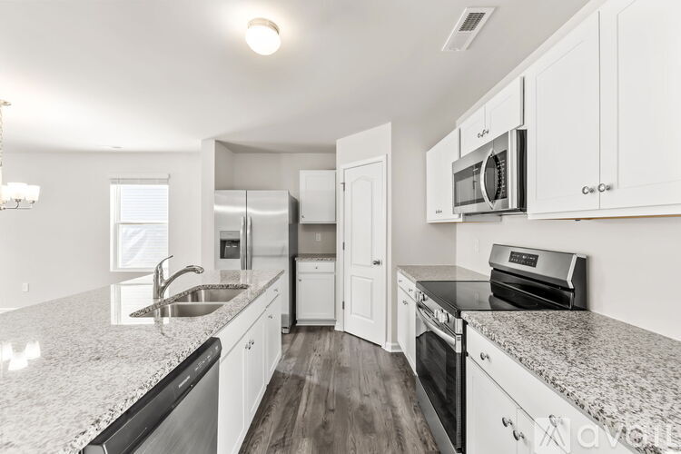 A kitchen with white cabinets and granite countertops.