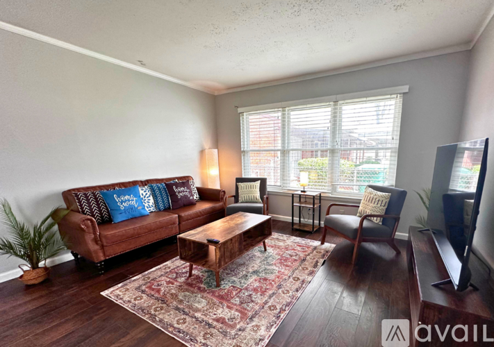 A living room with a brown couch, a coffee table, and a television.