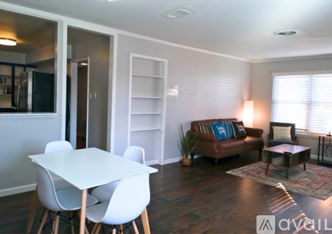 A living room with a white dining table and white chairs.