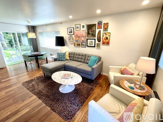 A living room with a grey couch, a white armchair, and a coffee table.