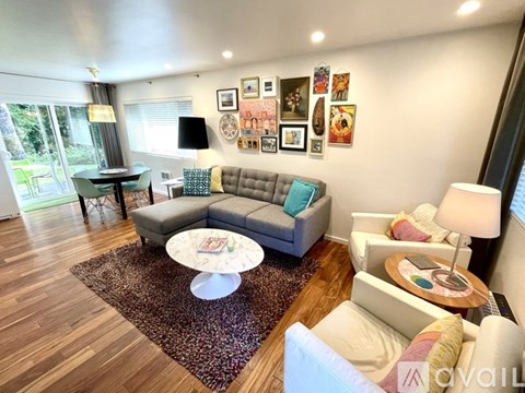 A living room with a grey couch, a white armchair, and a coffee table.