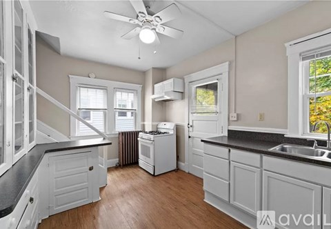 A kitchen with white cabinets and a black countertop.