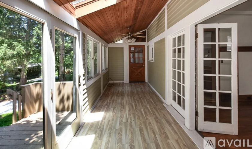 A sunny day in a house with a wooden deck and sliding glass doors.