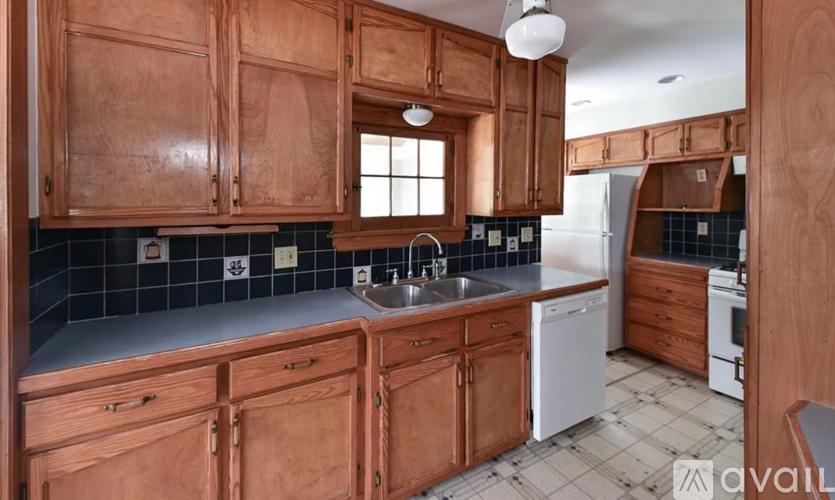 A kitchen with wooden cabinets and a white dishwasher.