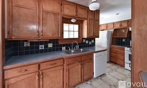 A kitchen with wooden cabinets and a white dishwasher.