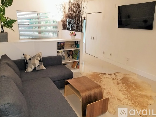 A living room with a grey couch and a wooden coffee table.