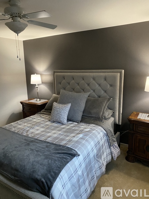 A bedroom with a large bed and a ceiling fan.