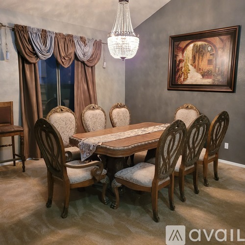 A dining room with a table and chairs.