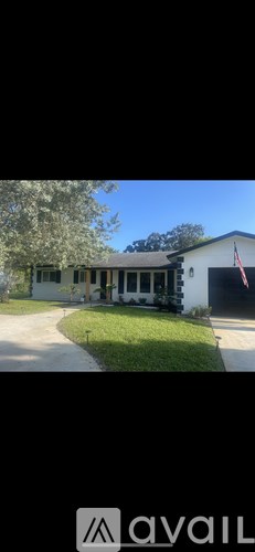 A white house with a black roof and a flag on the right side.