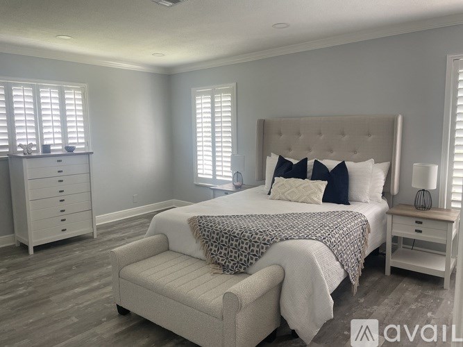 A bedroom with a bed, nightstand, and chair.