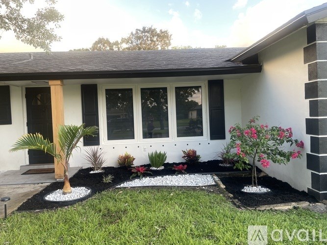 A house with a white exterior and a garden in front.