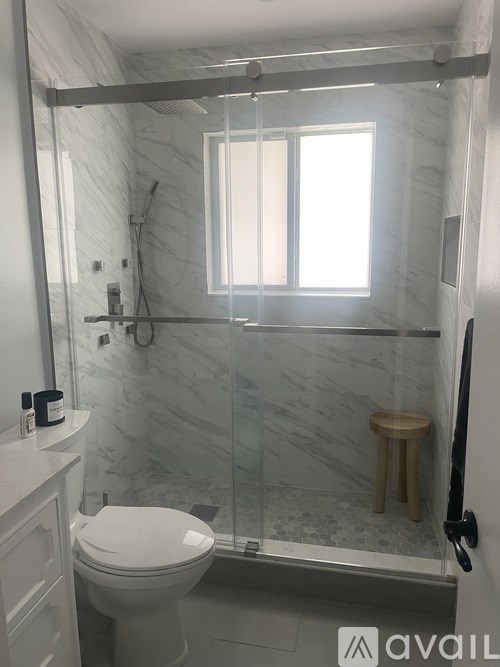 A white toilet in a bathroom with a glass shower door.