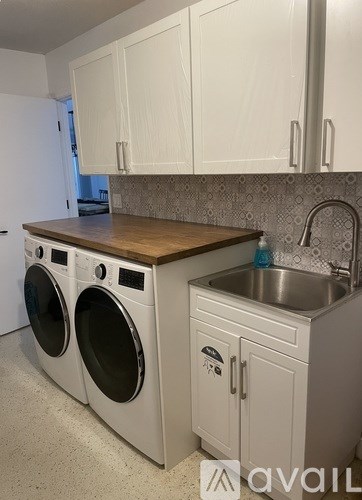 A kitchen with a washer and dryer built into the cabinetry.