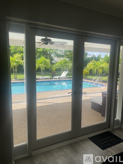 A patio with a pool and a ceiling fan.