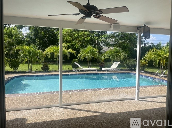 A pool with a chair and a fan in the background.