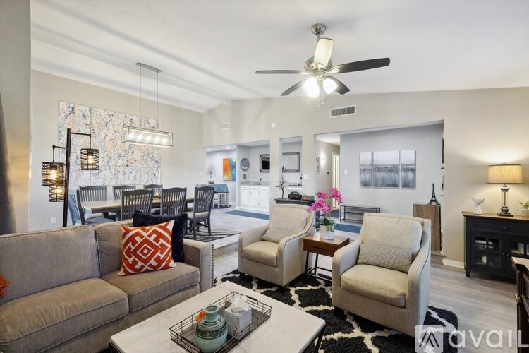 A living room with a grey couch, a coffee table, and a ceiling fan.