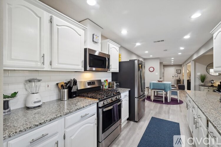 A kitchen with white cabinets and a granite countertop.