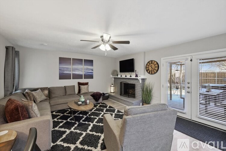 A living room with a grey couch, a coffee table, and a fireplace.