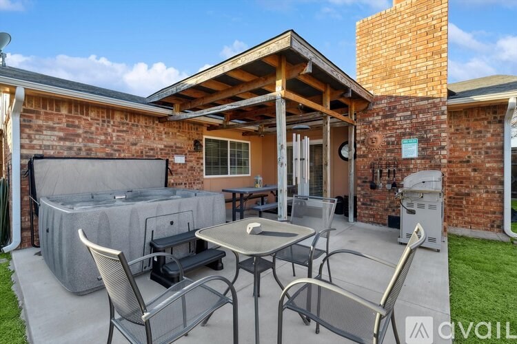 A patio with a table and chairs is set up outside a house.