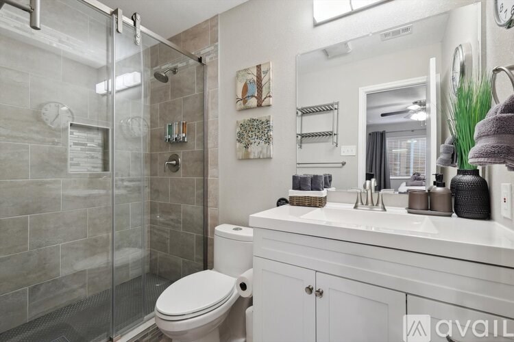 A bathroom with a toilet, sink, and shower.
