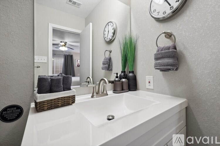 A bathroom with a white sink and a mirror above it.