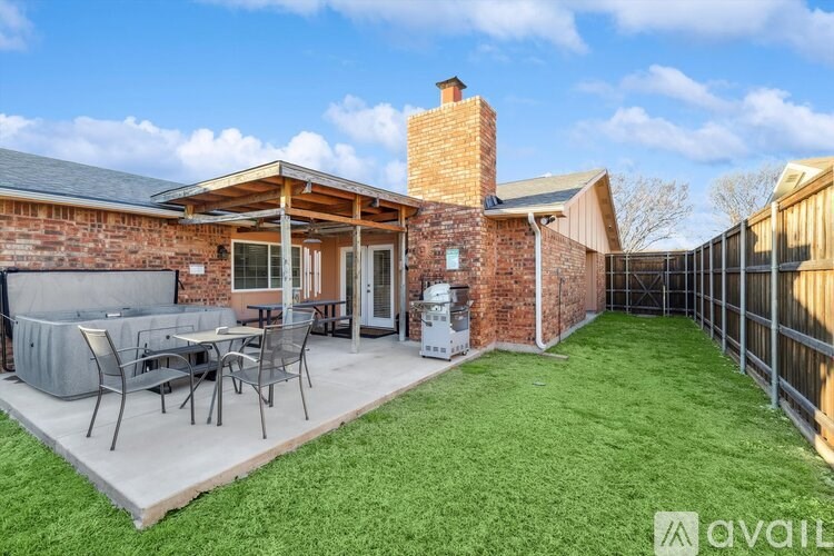 A backyard with a patio and a brick house.