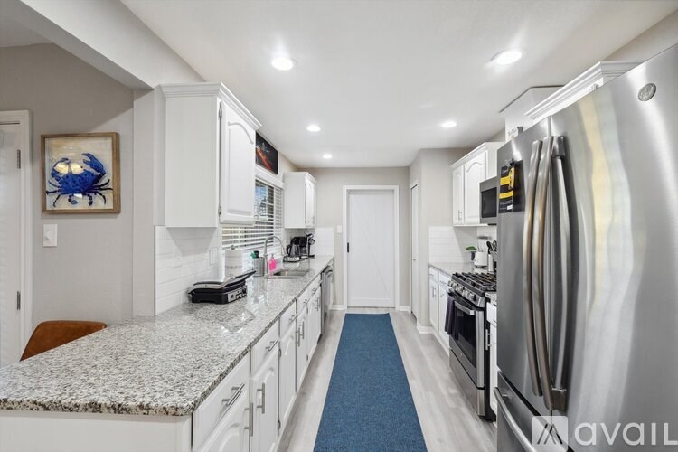 A kitchen with a granite countertop and stainless steel appliances.