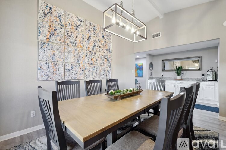 A dining room with a wooden table and chairs.