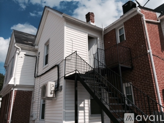 A white house with a black metal staircase.