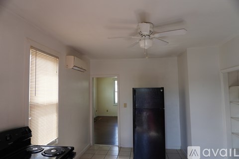 A white fridge in a room with a ceiling fan.